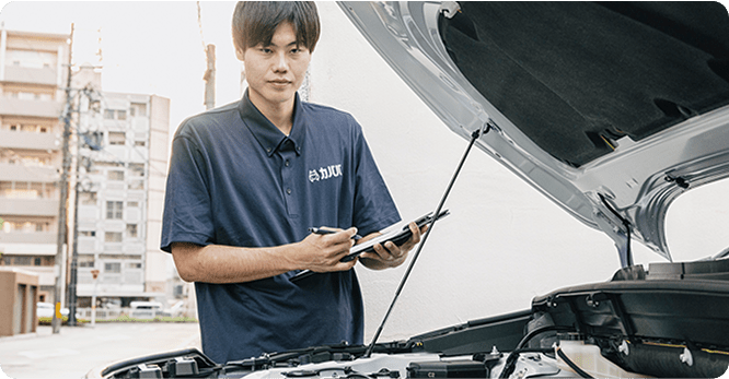 男性がボンネットを開けて査定している様子