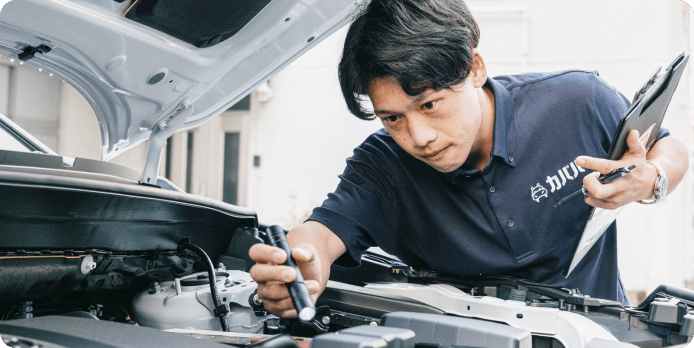 男性が車のボンネットを開けて査定をしている様子